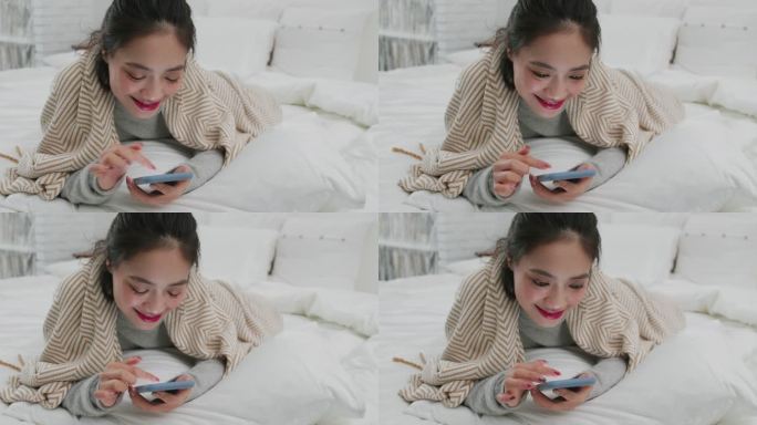 年轻美女躺在床上玩手机刷视频