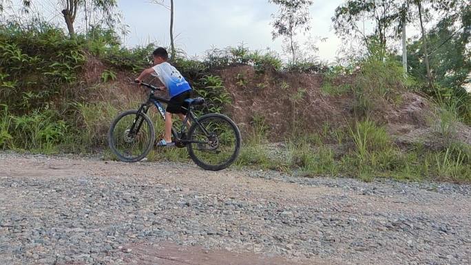 乡村傍晚小孩骑车骑自行车村孩子顽皮小孩