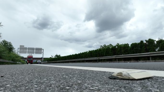 低角度拍摄乌云下高速公路过往的汽车