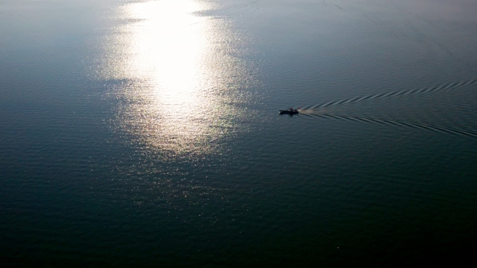 夕阳下平静海面上的渔船（两种调色）