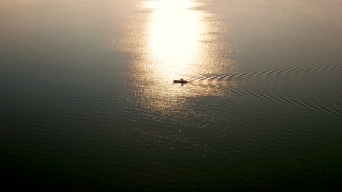 夕阳下平静海面上的渔船（两种调色）视频素材