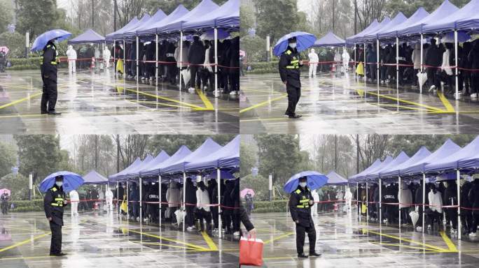 下雨天市民排队在城市广场上做核酸