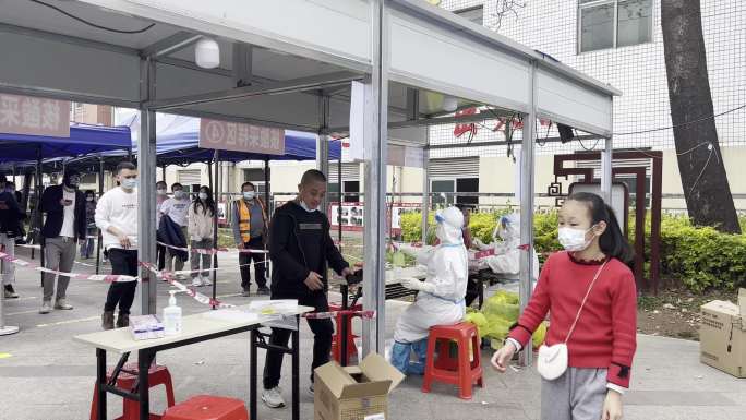 市民在雨棚下排队做核酸