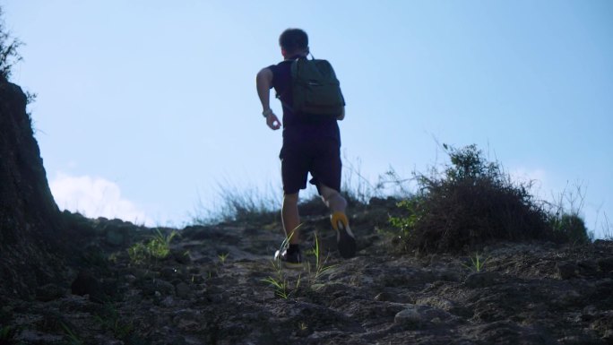 逆光奔跑的脚步-男人跑向山顶背影