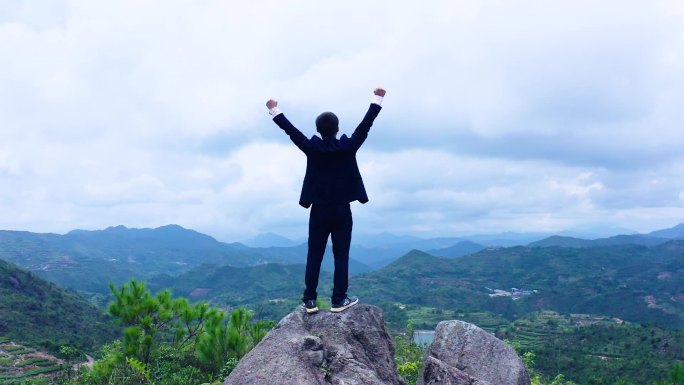 登顶男人背影航拍-向着远方举起手臂-信念