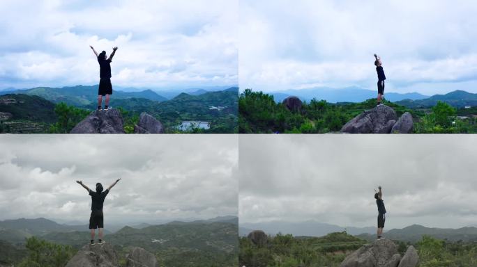 站在山顶向着天空举起双臂航拍