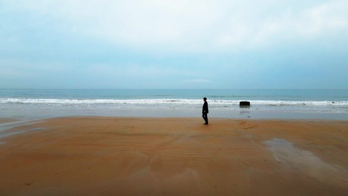 男人在海边悠闲散步大气意向实拍