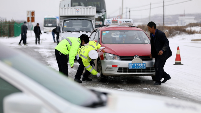 雪中交警帮助出租车司机安装防滑链