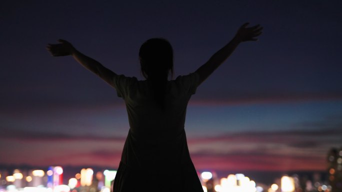 4K一位年轻女性在楼顶天台看城市晚霞放松