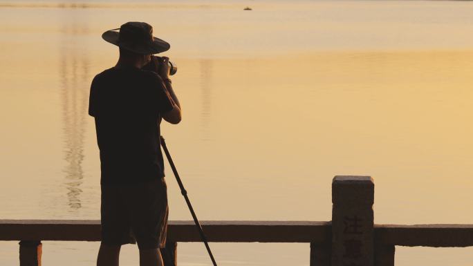 在落日余晖中拍摄的摄影师背影
