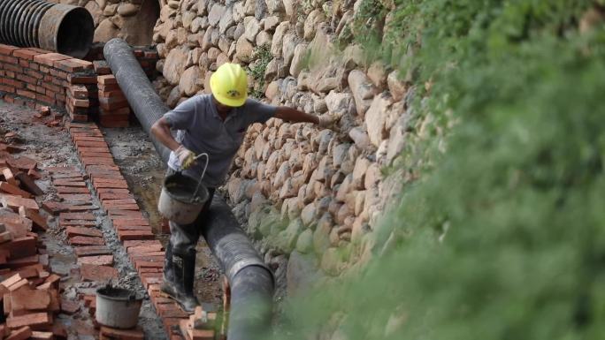 工人修排水管道铺砖