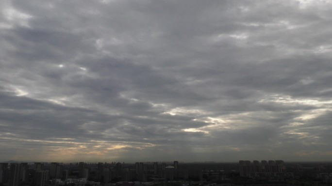 城市日出阴天乌云满天阳光透过云层的霞光