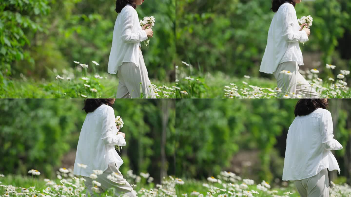 慢镜头拍摄美女拿着鲜花走在春天草地公园里