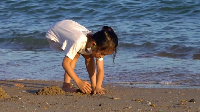 小女孩海边沙滩上玩沙子