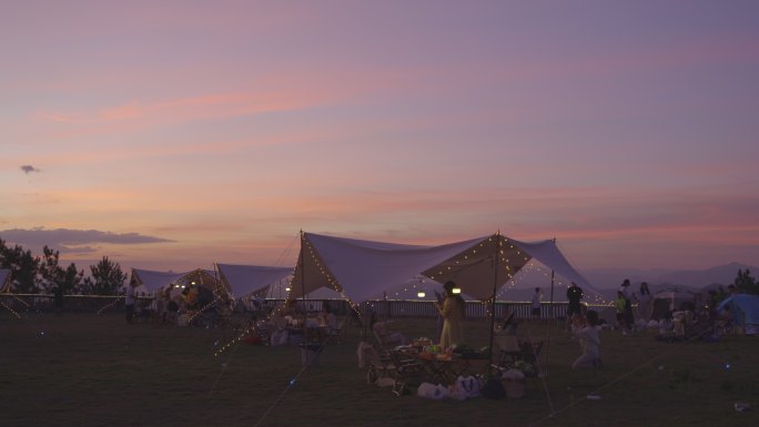 黄昏时刻一群人在露营野餐
