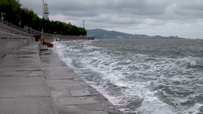 阴雨天海浪拍打岸边激起浪花