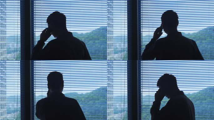 男人窗边打电话频频点头沟通工作客户维护