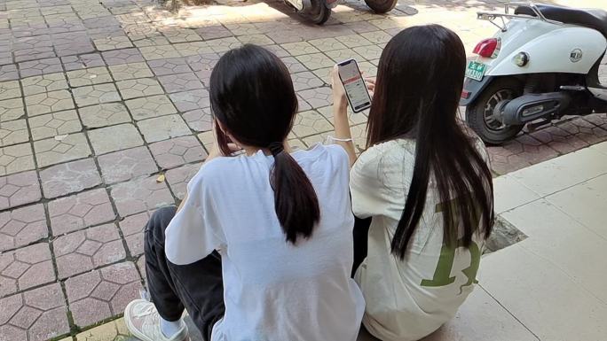 玩手机的女孩子坐着玩手机看手机的女学生