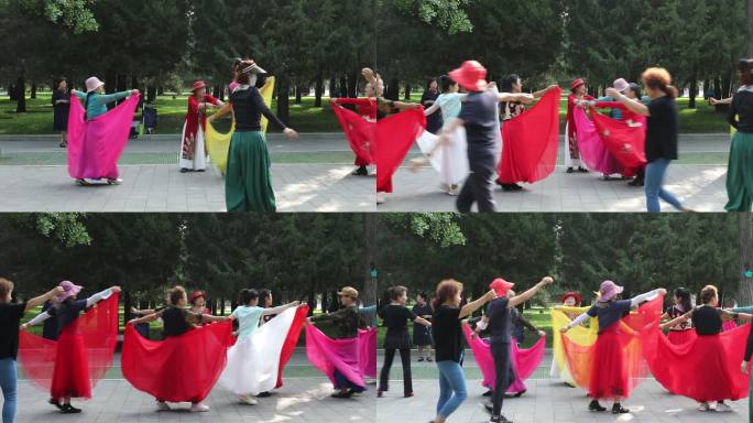 公园里一位老师指导身着少数民族服装的跳舞