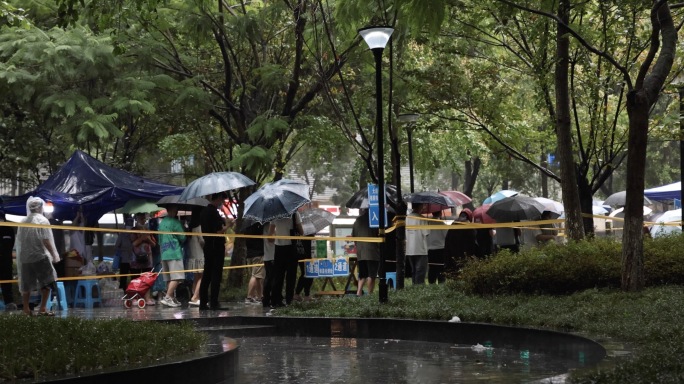 下雨 车流 行人 雨中打伞排队核酸