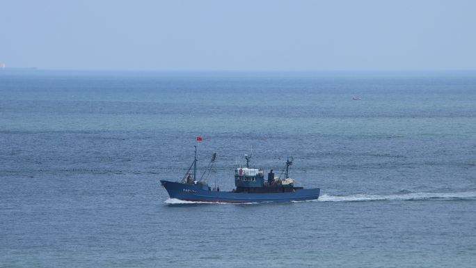 一条渔船驶过海面