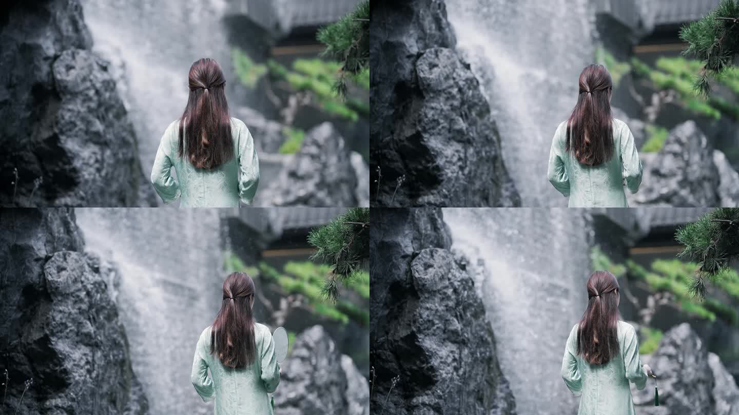 身穿汉服年轻女子走向园林景观水景墙上瀑布
