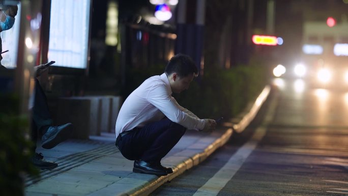 深夜蹲在路边等公交的男人