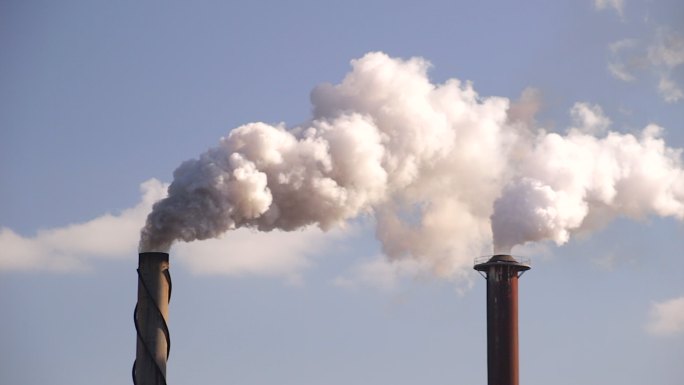 工厂午后阳光下烟囱造成的空气污染。