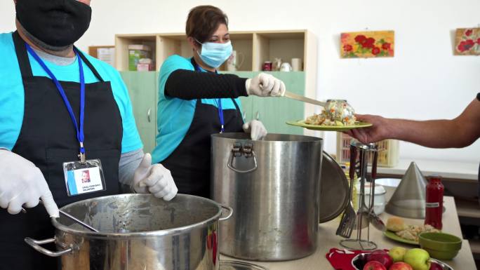 慈善工作者在为饥饿的人提供救济的厨房里帮忙