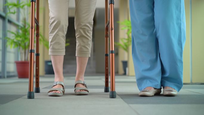 家庭护理人员帮助老年妇女使用行走架