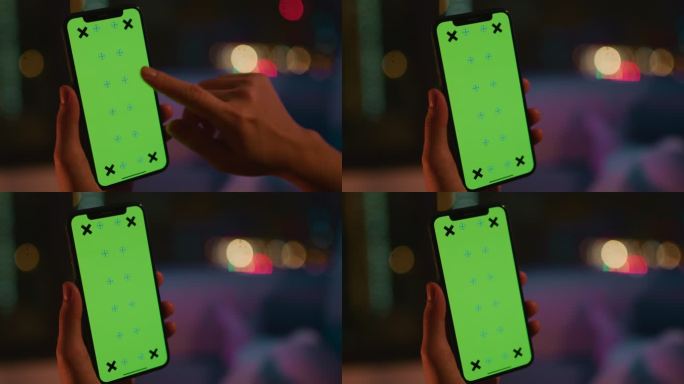 一名妇女在夜间使用绿色屏幕的电话