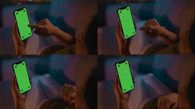 一名妇女在夜间使用绿色屏幕的电话