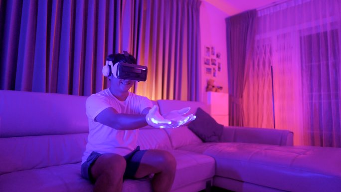 一名亚洲年轻男子在网上约会时戴着虚拟现实眼镜