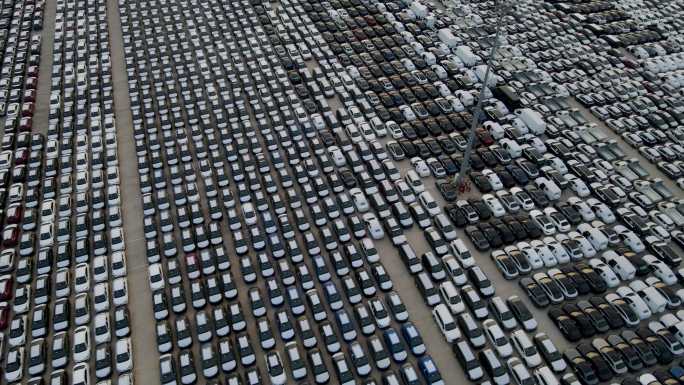 巨大的储存停车场，汽车排成一排，准备分发的新车库，航拍俯视图，用于运输船护航车或进出世界市场的车辆的