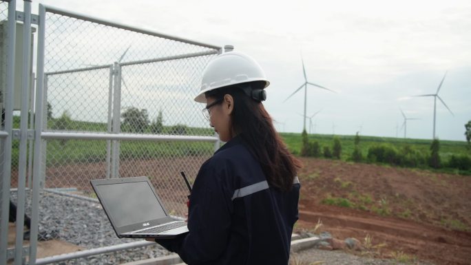 亚洲工程师正在检查风力涡轮机。