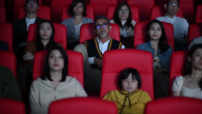 坏习惯：一个粗鲁的亚裔中国高级男子在电影放映期间在黑暗中大声地通过电话扬声器说话，干扰并忽视周围的其