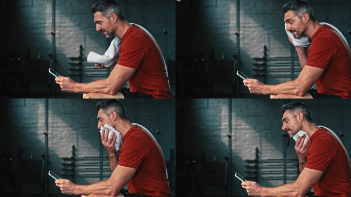 4k视频画面，一个英俊成熟的男子独自坐在健身房，锻炼后使用手机