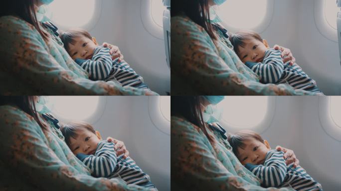 坐飞机旅行时，男孩睡在母亲的怀里。