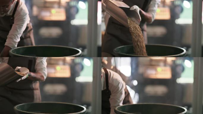 特写：中段：一名亚裔中国工人，一名高级工人，正在工厂仓库里舀生咖啡豆，将桶装满称重机，并将其混合用于