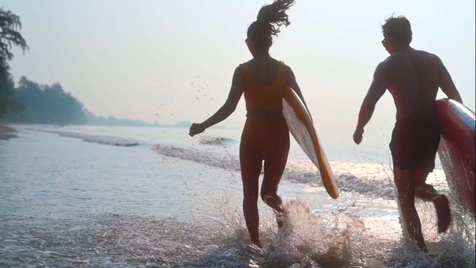 夏季运动海边冲浪奔跑情侣海边冲浪度假