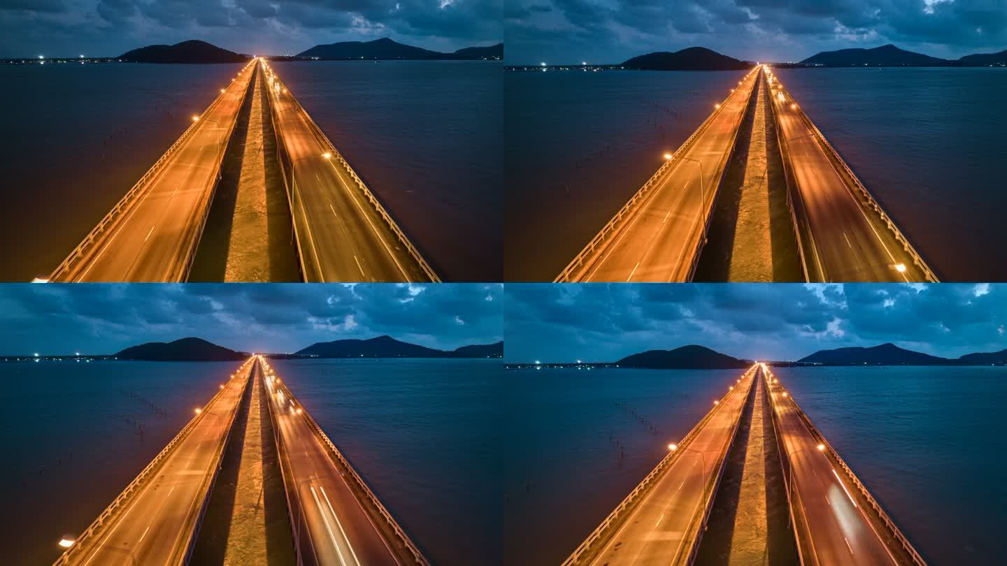 空中无人机超延时或延时夜景，Tinsulanonda大桥松克拉湖大桥上的交通车。泰国松克拉湖桥沿线