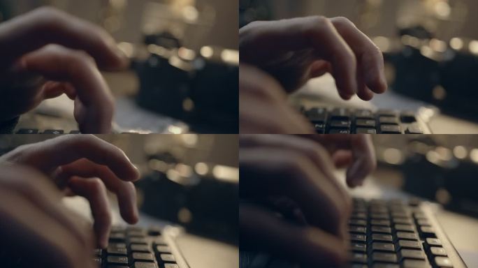 一名男子的指尖在电脑键盘上快速敲击的特写镜头