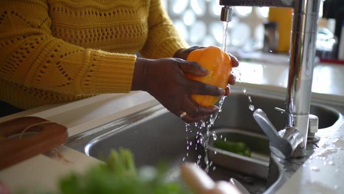一位年长女性在家洗甜椒的特写镜头