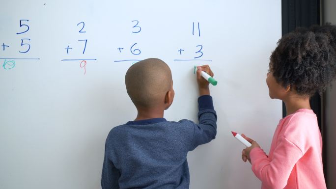 两个非洲裔美国儿童在白板上做数学