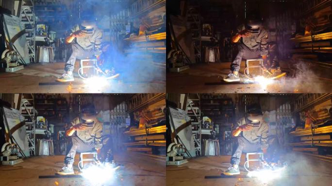 慢动作亚裔马来人焊工在车间焊接，使用焊炬修理