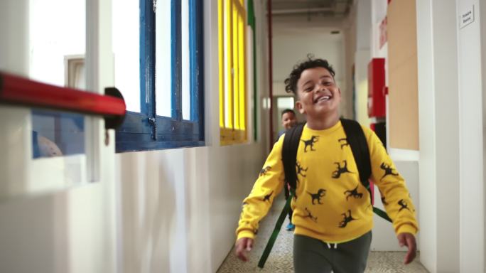 微笑着的孩子们匆匆穿过学校走廊