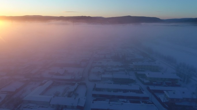 航拍冷空气笼罩森林小镇雪景