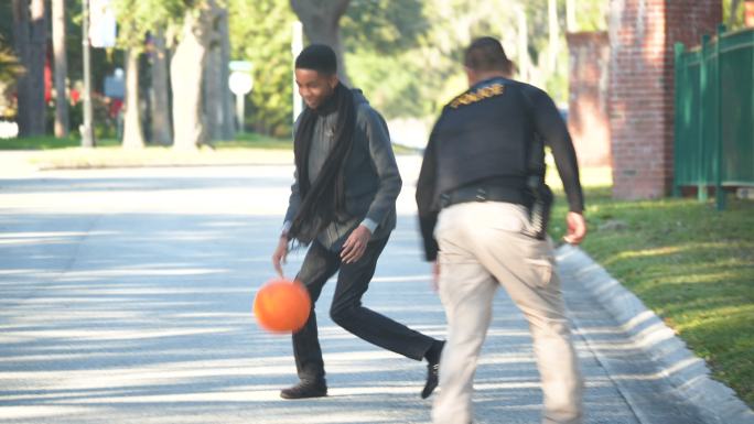 警官正在和两个年轻人打篮球