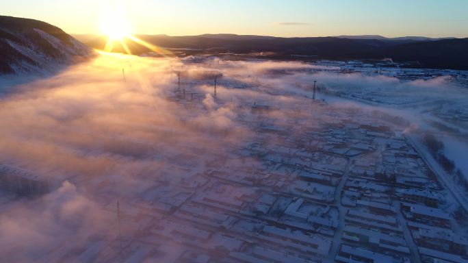 航拍冷空气笼罩森林小镇雪景