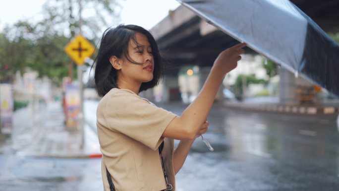 亚洲女人打开伞大雨来临一个人无助美女撑伞